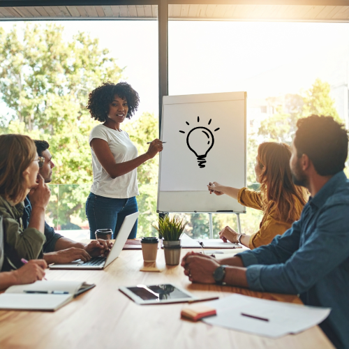 woman pitching ideas to group of people around table
