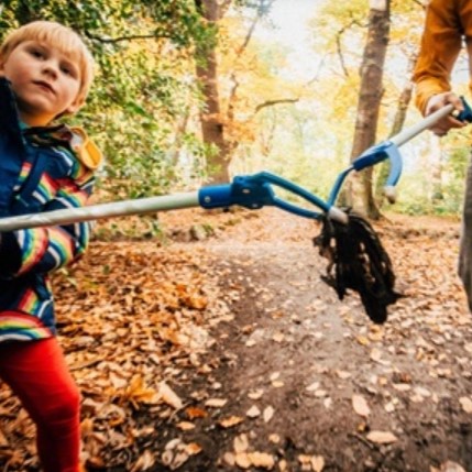 Child picking up rubbish in woodlands