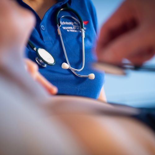 A person using a stethoscope on a patient
