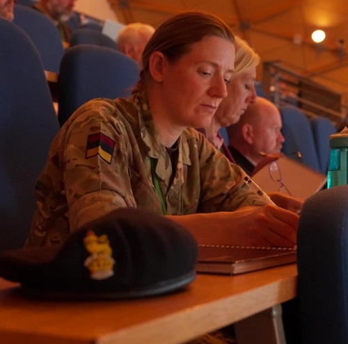 A soldier in uniform in a lecture theatre