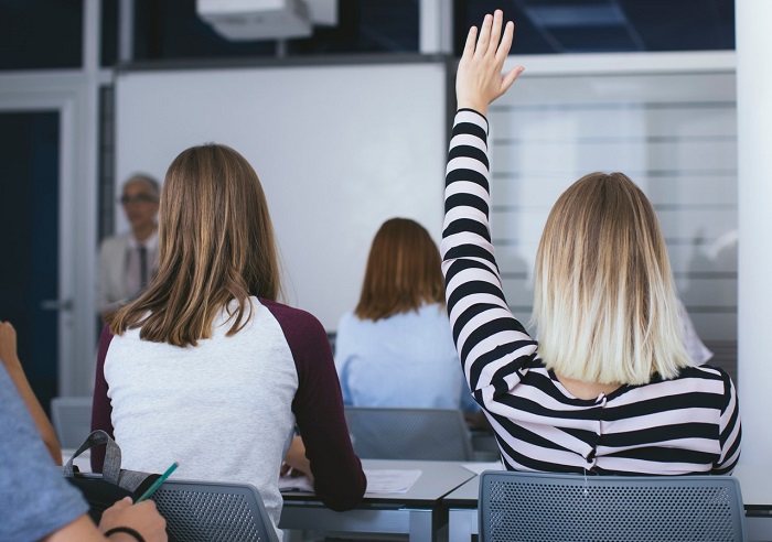 Woman with her hand up in a classroom