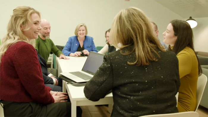 group of people around a table chatting